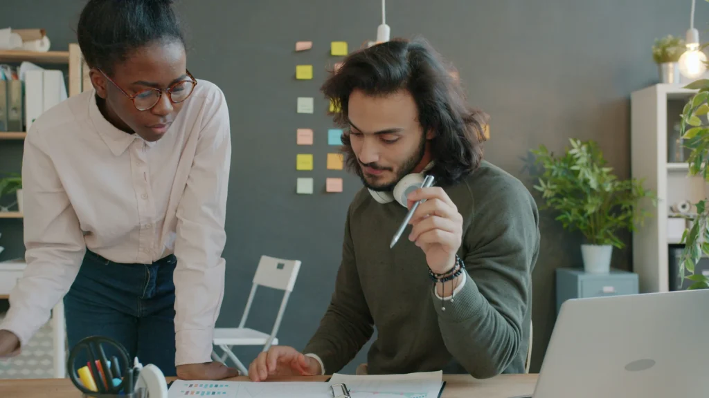 Colleague coaching a NetSuite administrator at a desk