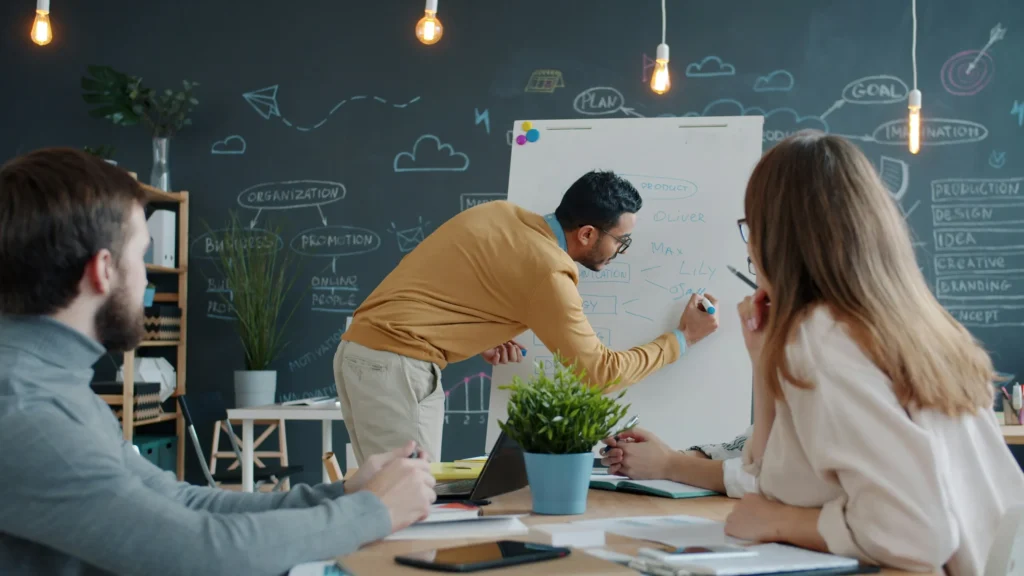 Team member explaining a process on a whiteboard