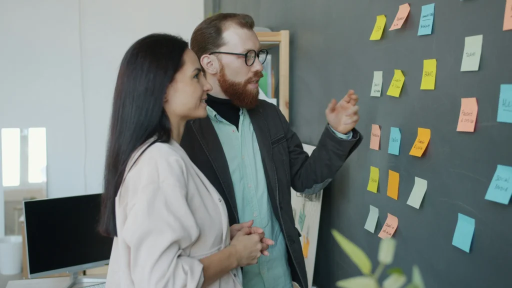 Two colleagues mapping a process with sticky notes