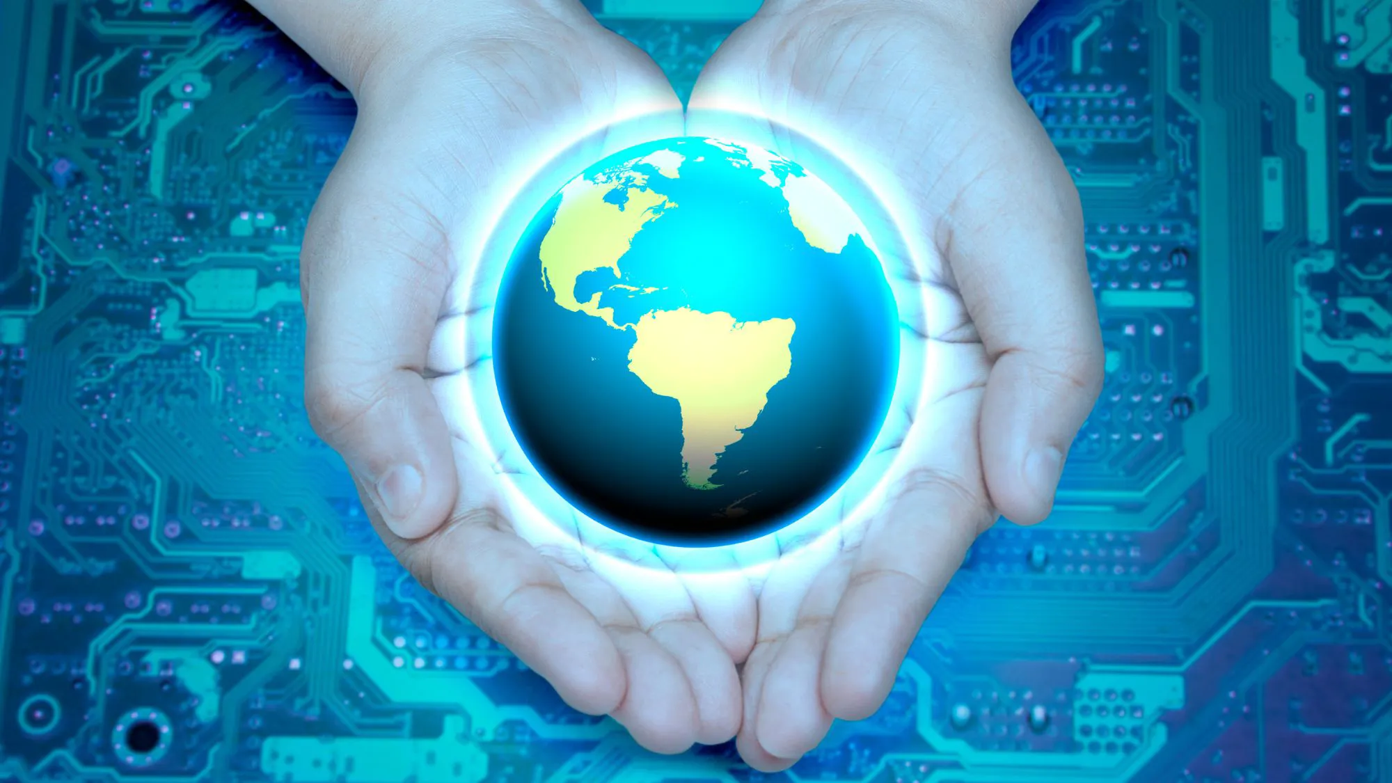 Hands holding a globe above a circuit board