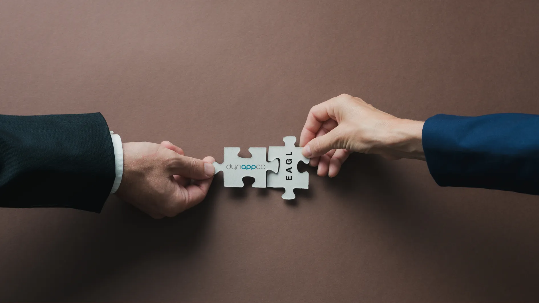 Two hands joining puzzle pieces, symbolising the Eagl and Dynappco partnership